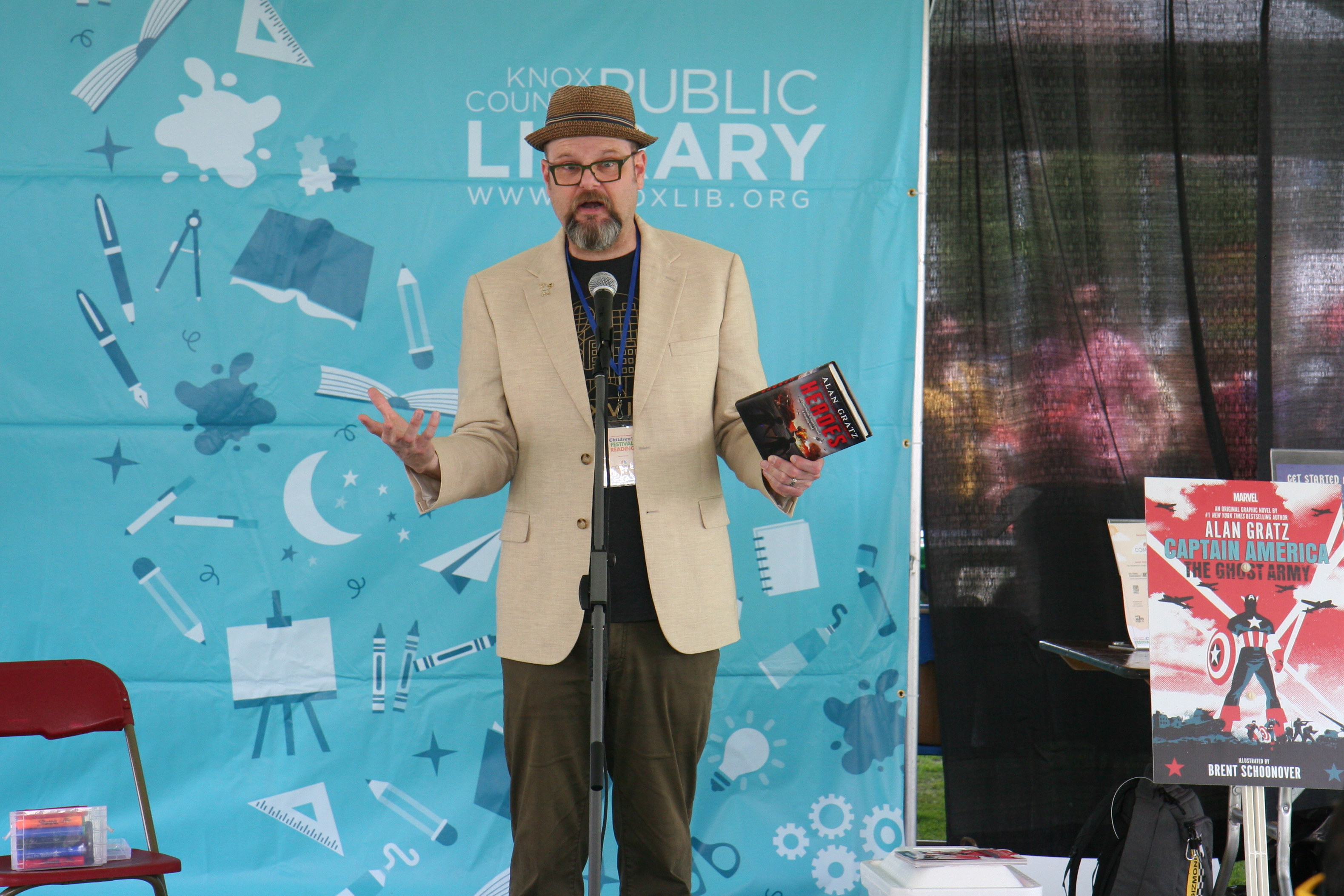 author Alan Gratz stands in front of a microphone