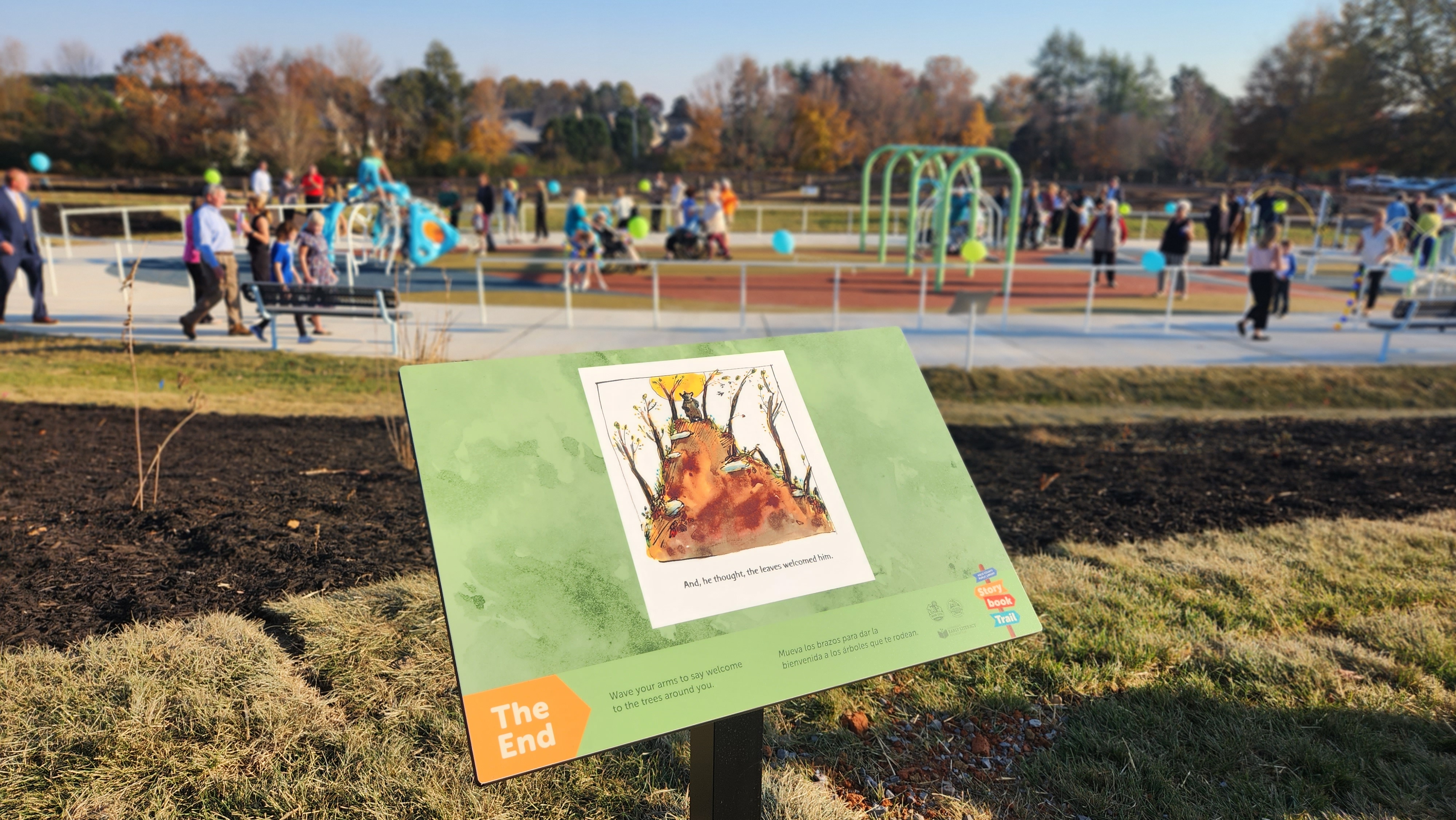 photo of storybook trail panel in foreground with playground in background