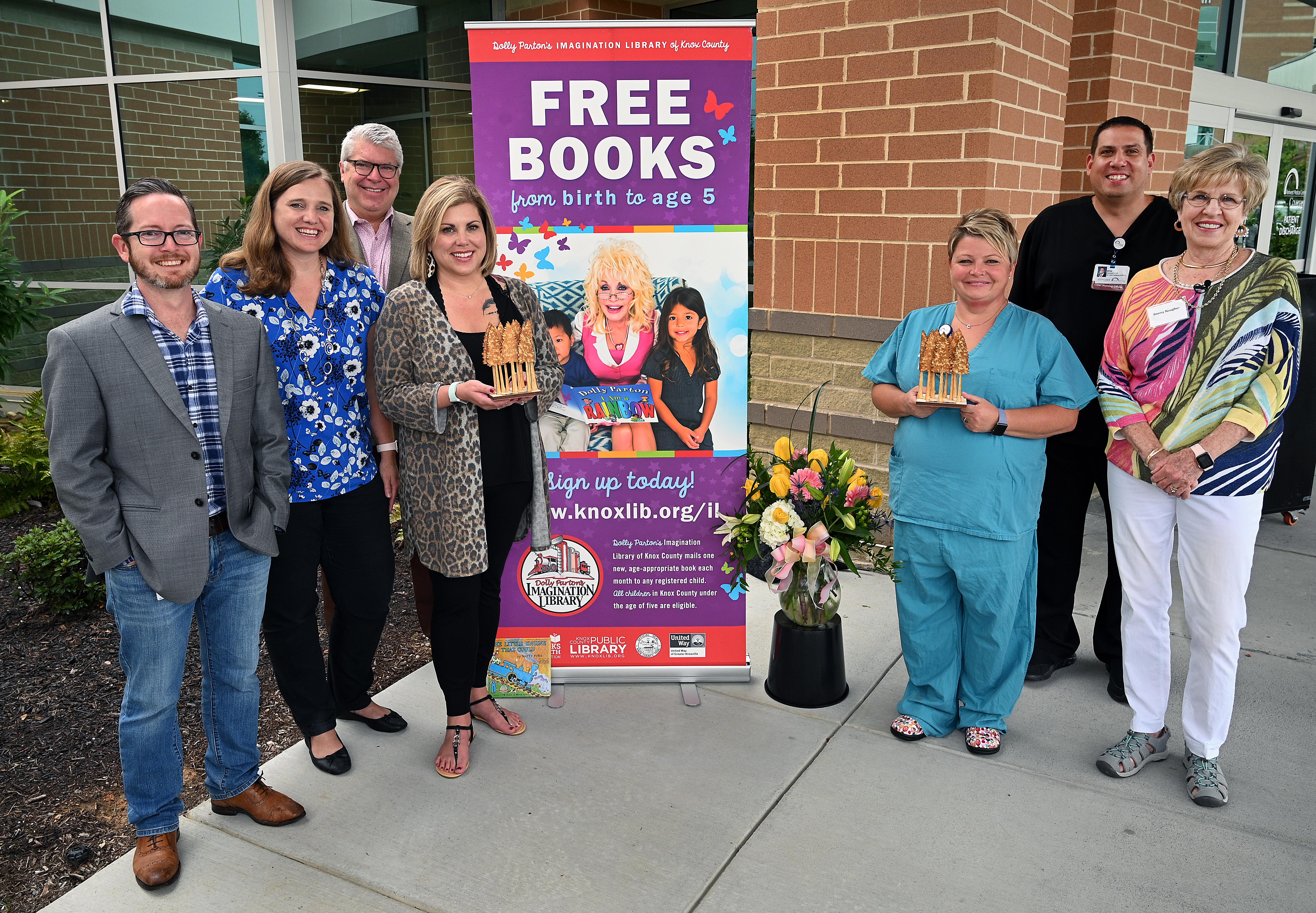 Board members and Awardees pose together in front of the Dolly Parton's Imagination Library banner outside of Parkwest Medical Center