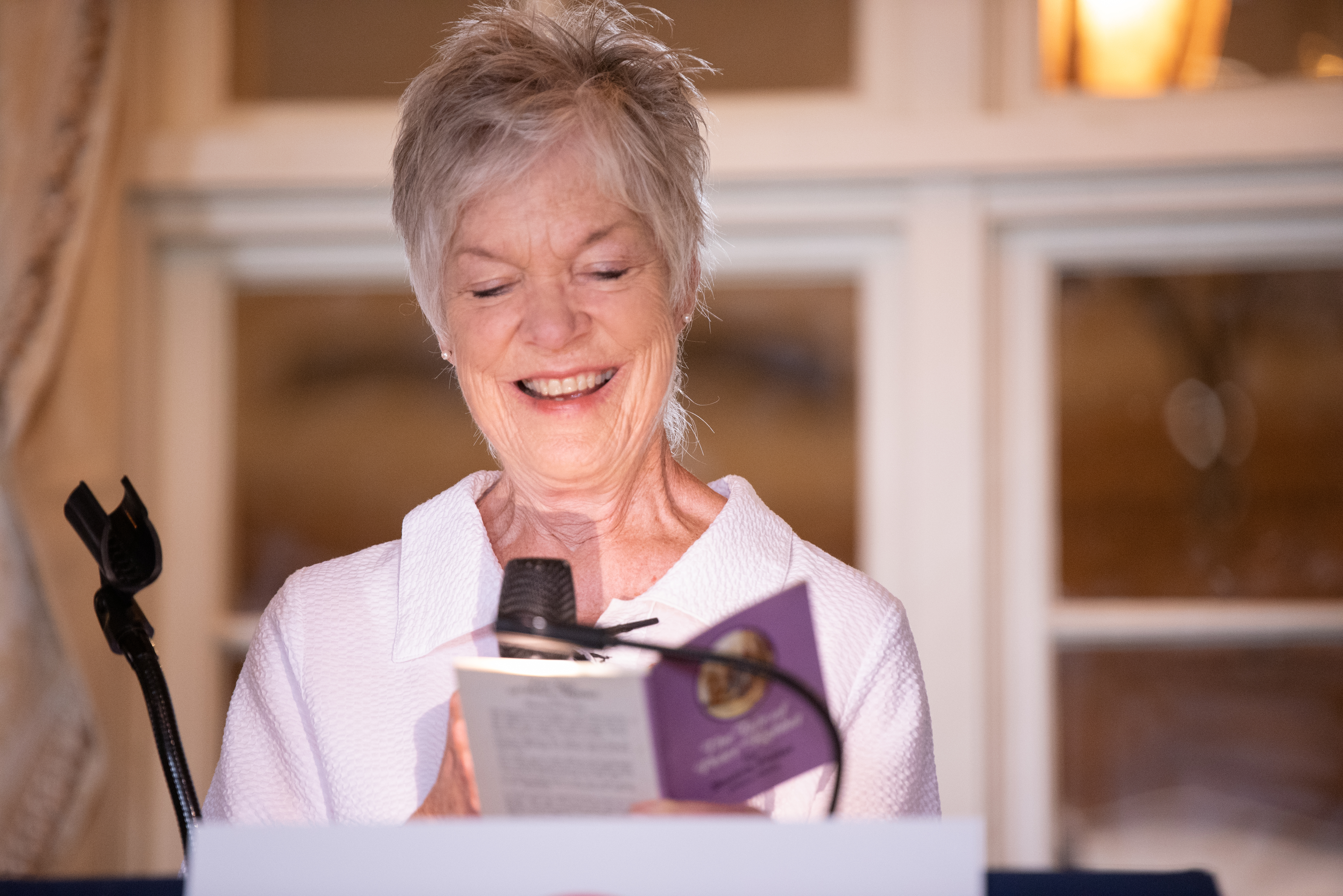 Jinx Watson reads from a purple-covered copy of Peter Rabbit by Beatrix Potter during her acceptance speech.