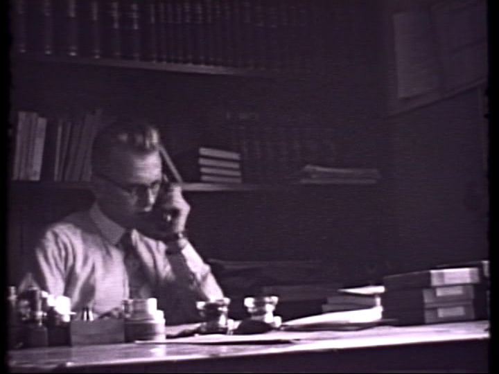 Walther Barth seated at a desk on the telephone