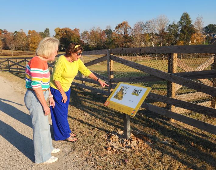 two women read a story trail panel