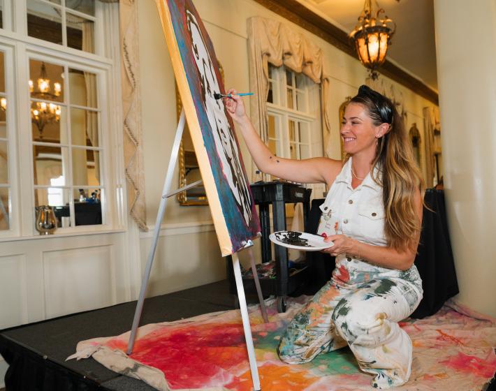 Jes Ramsey, local artist, painting a Dolly Parton painting as entertainment for Seeds of Imagination 2023