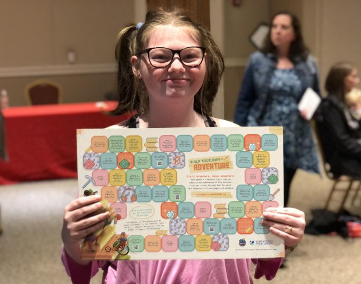 girl holds colorful gameboard