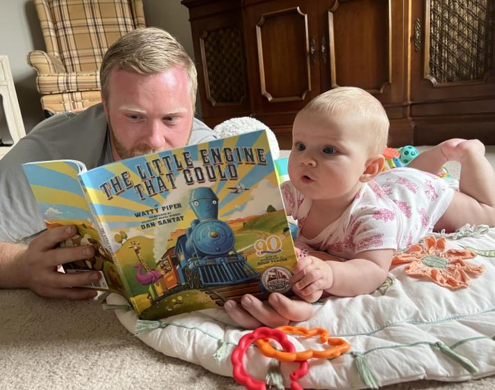 baby and dad reading The Little Engine That Could