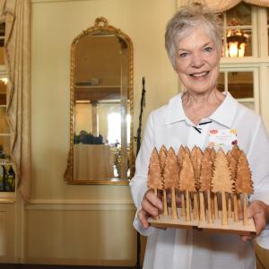 Jinx Watson holding the first Seeds of Literacy award: a pair of wooden bookends decorated with trees